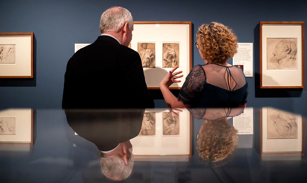 Curator Av van Camp and a Flemish guest at our Bruegel exhibition preview with their backs to the camera looking at the Rubens drawings