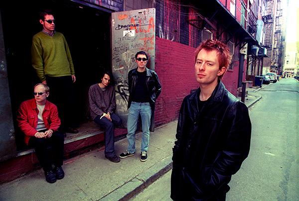 Five members of the band Radiohead lounging in back alley of a street, around 1996, when it was announced they would play T in the Park