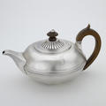 A silver teapot with wooden handle