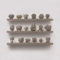 Unfired clay strange Ugg imaginary figures on a shelf by contemporary artist Daphne Wright