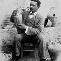Black and white photograph of Sir Arthur Evans holding a rhyton from the Hall of the Double Axes of the Palace of Minos at Knossos dated 1901