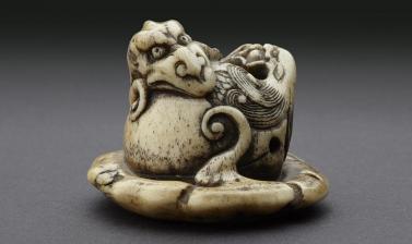 Netsuke in the form of a rain dragon coiled around a mokugyō, a Buddhist percussion instrument from the Ashmolean collections