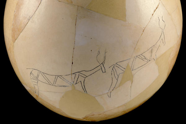 A reconstructed ostrich egg decorated with line drawings of animals