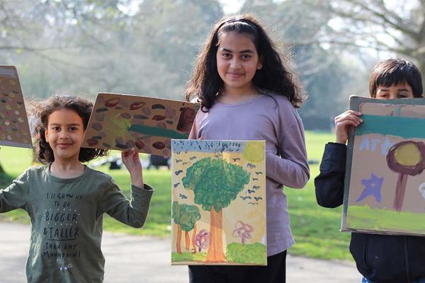 Children holding up their art at our Painting in the Park event in Oxford in March 2022