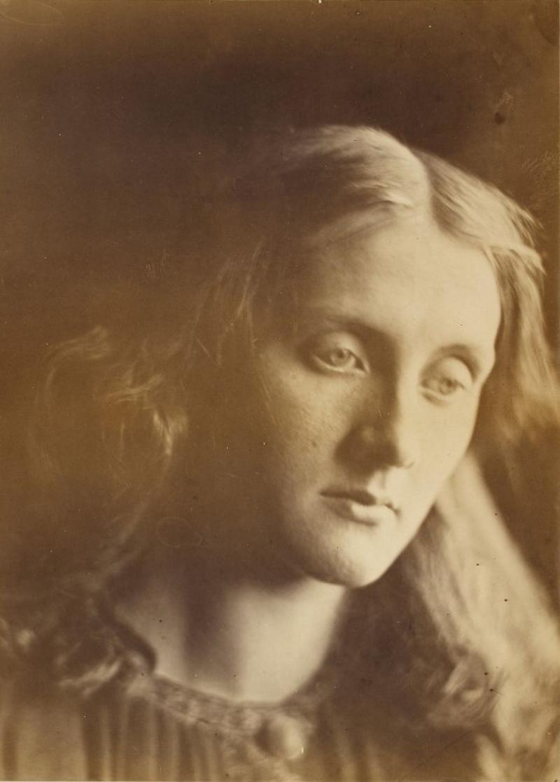 Sepia-coloured picture portrait of a woman looking down, with long loose hair framing her face