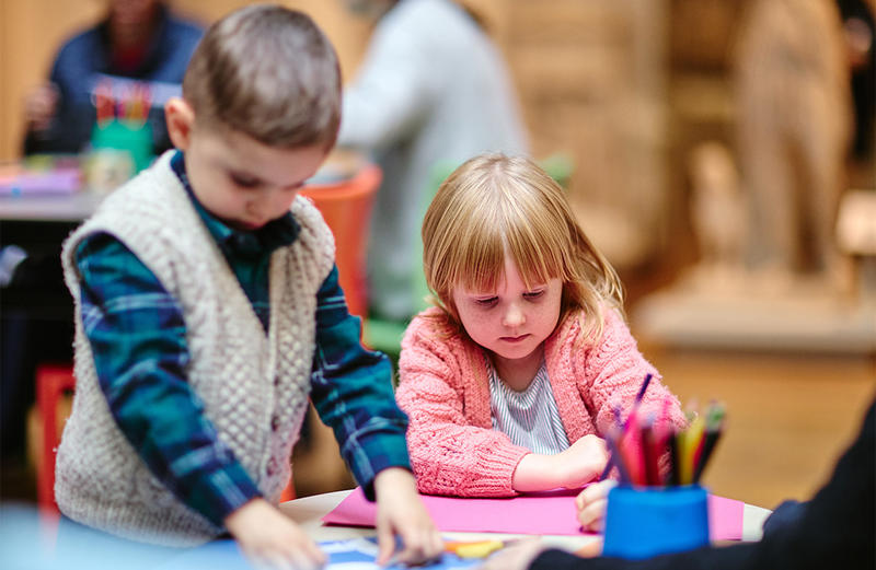 Two children making things at a family workshop 