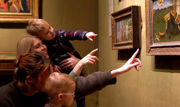 Family with children pointing at St Nicholas painting 