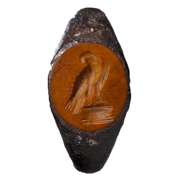 The face of an iron ring with a rough carving of an eagle